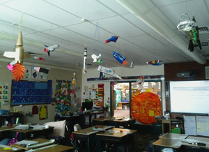 Model spacecraft hanging from ceiling in classroom
