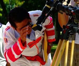 Maya man observes the Sun through a special telescope.